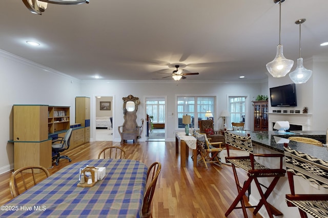 dining room featuring light wood-type flooring, ceiling fan, and crown molding