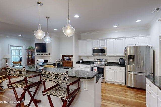 kitchen with white cabinets, pendant lighting, sink, and appliances with stainless steel finishes