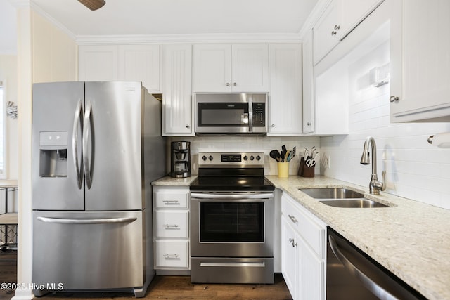 kitchen with decorative backsplash, light stone countertops, stainless steel appliances, sink, and white cabinets