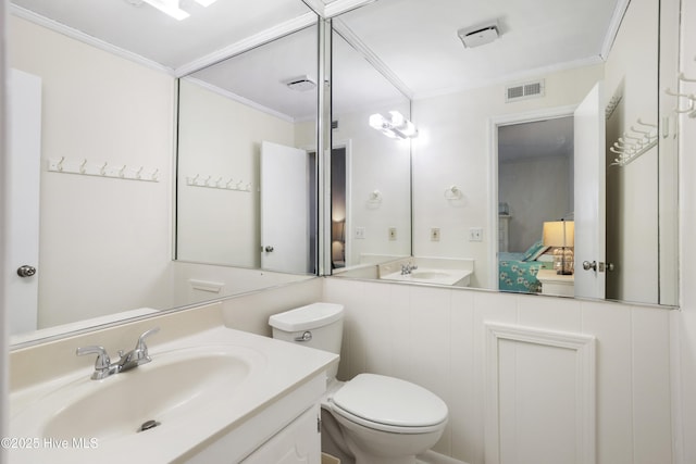 bathroom with vanity, toilet, and ornamental molding