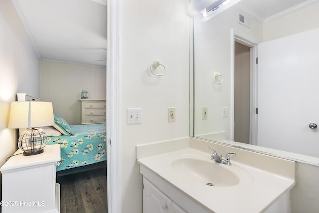 bathroom featuring hardwood / wood-style flooring, vanity, and ornamental molding