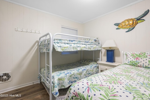 bedroom with dark hardwood / wood-style flooring and ornamental molding