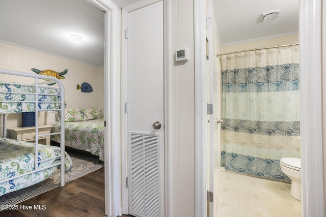 bedroom with wood-type flooring, ornamental molding, and a closet