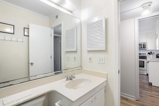 bathroom with wood-type flooring, vanity, and ornamental molding