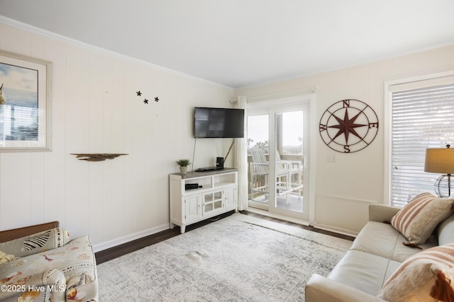 living room with hardwood / wood-style floors, ornamental molding, and a healthy amount of sunlight