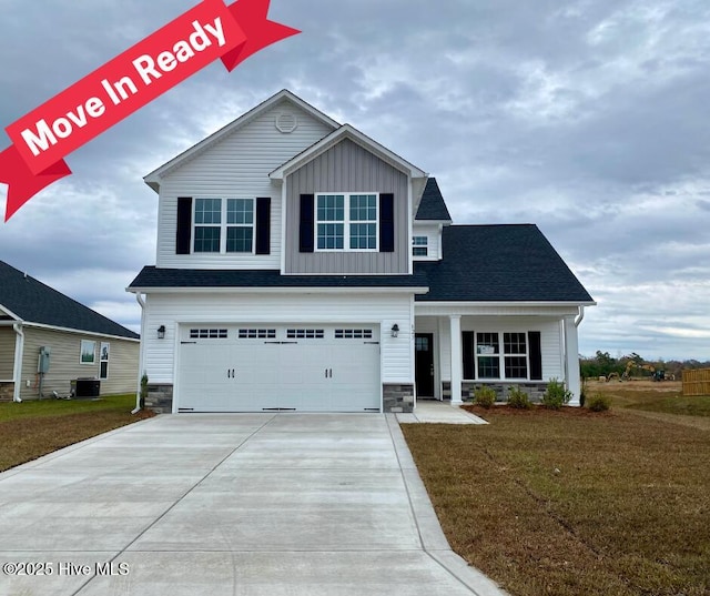 view of front of property featuring a front lawn, a garage, and cooling unit