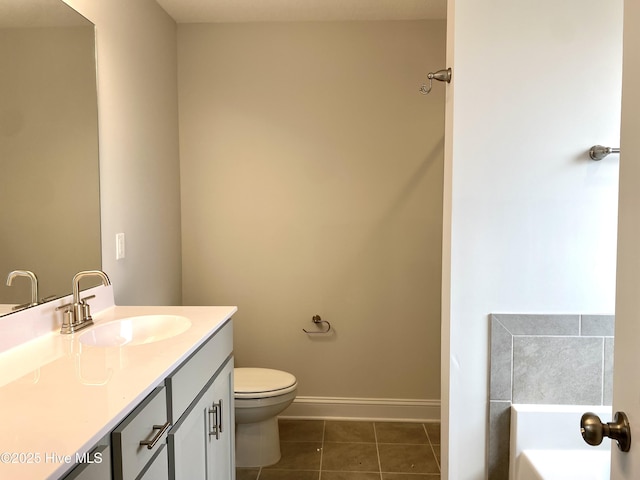 bathroom featuring tile patterned floors, vanity, a bathtub, and toilet