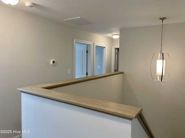 hall featuring a textured ceiling