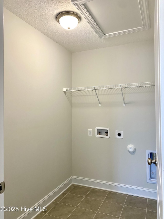 clothes washing area featuring a textured ceiling, washer hookup, dark tile patterned flooring, and hookup for an electric dryer