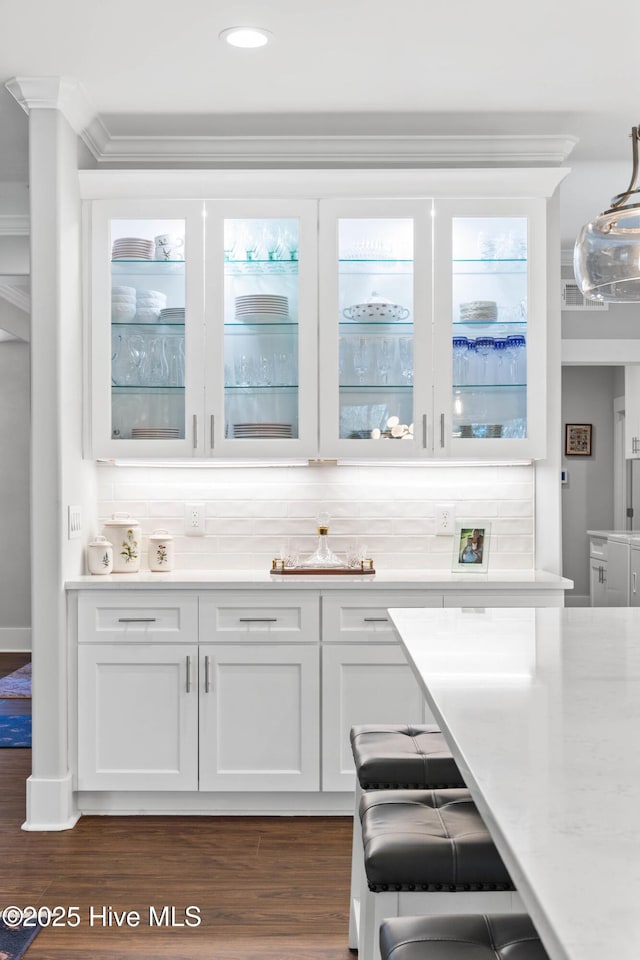 bar featuring white cabinetry, decorative backsplash, dark hardwood / wood-style floors, and hanging light fixtures