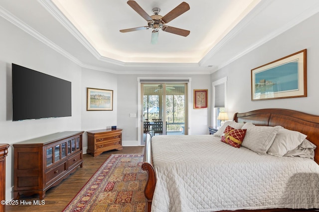 bedroom featuring ceiling fan, a raised ceiling, access to exterior, dark hardwood / wood-style flooring, and crown molding