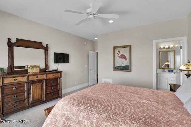 bedroom with light carpet, ensuite bathroom, and ceiling fan