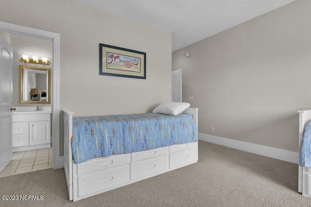 bedroom featuring sink, light carpet, and ensuite bath