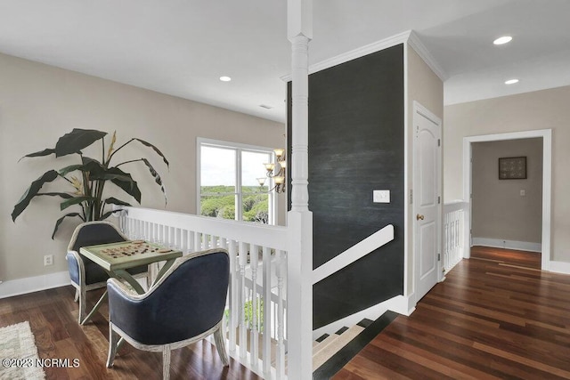 corridor with dark hardwood / wood-style floors, an inviting chandelier, and crown molding