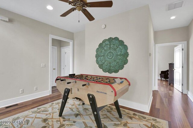 playroom with ceiling fan and dark wood-type flooring