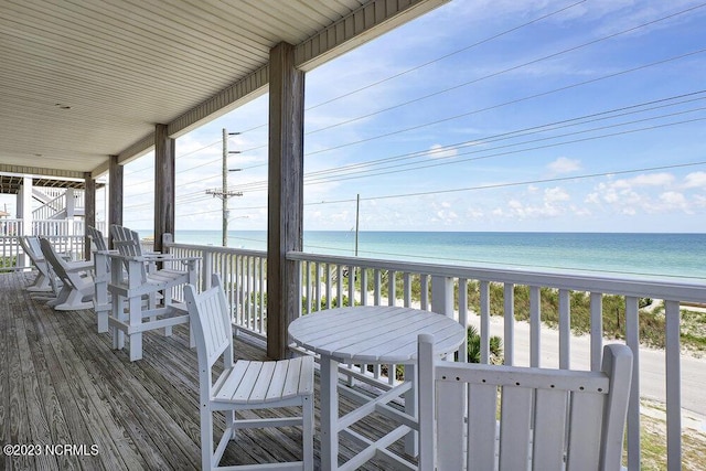 wooden deck with a water view and a view of the beach