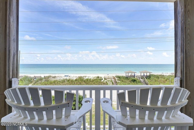 balcony featuring a water view and a beach view