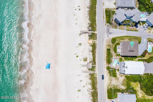 bird's eye view featuring a water view and a beach view