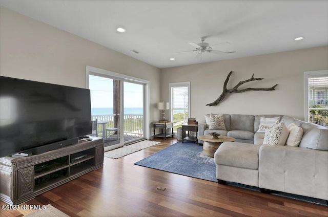 living room with dark hardwood / wood-style flooring and ceiling fan