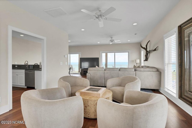 living room featuring plenty of natural light, dark wood-type flooring, and ceiling fan