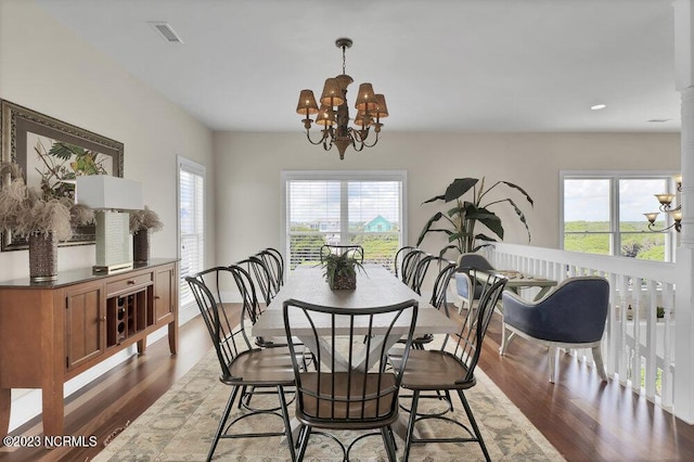 dining room with dark hardwood / wood-style flooring and a notable chandelier