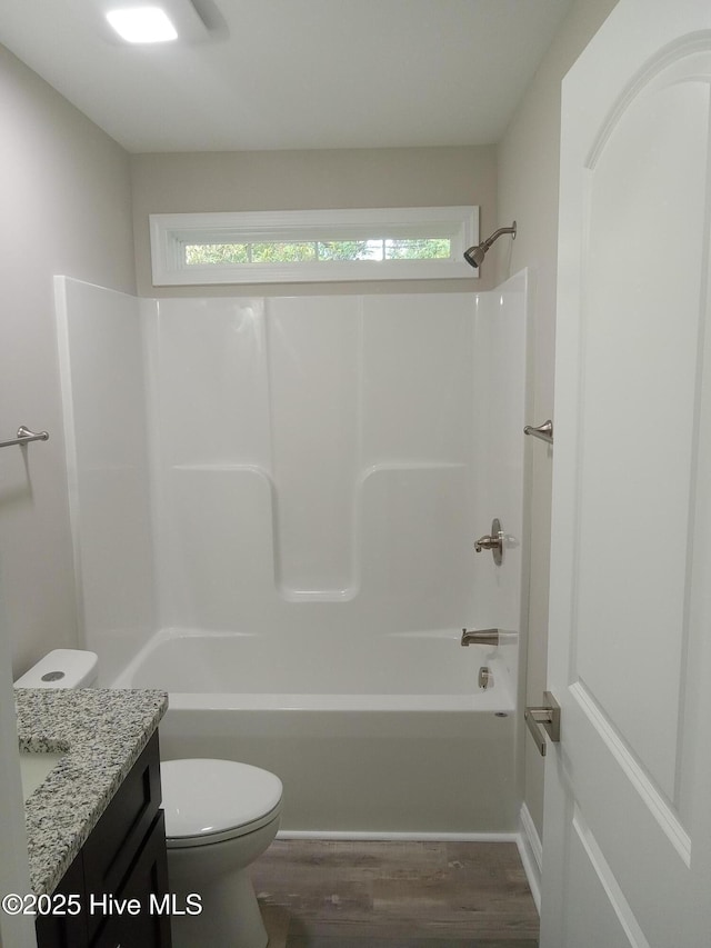 full bathroom featuring hardwood / wood-style flooring, vanity, shower / bathtub combination, and toilet