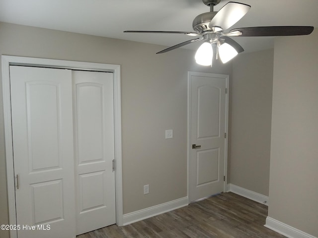 unfurnished bedroom with a closet, ceiling fan, and dark wood-type flooring