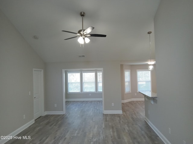 unfurnished living room with ceiling fan, dark wood-type flooring, and vaulted ceiling