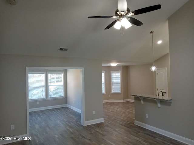 unfurnished living room featuring dark hardwood / wood-style flooring, vaulted ceiling, ceiling fan, and sink