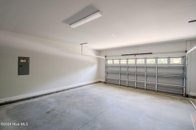 garage featuring electric panel and baseboards