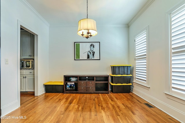 sitting room with crown molding and hardwood / wood-style flooring