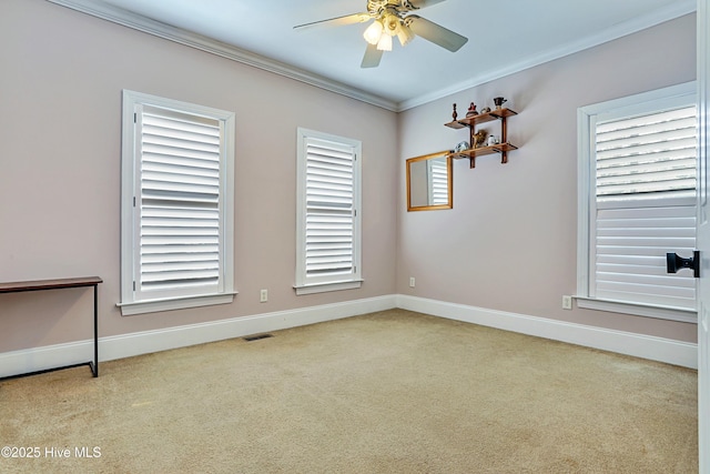 unfurnished room featuring a healthy amount of sunlight, ornamental molding, and ceiling fan