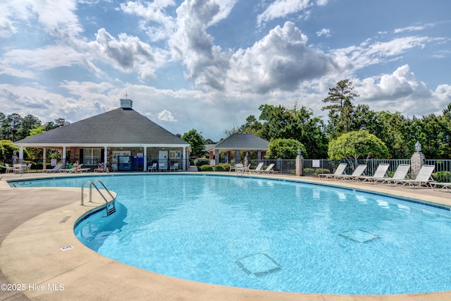 community pool with a gazebo, a patio area, and fence