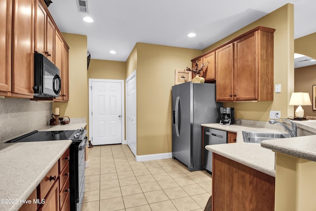 kitchen with visible vents, black appliances, a sink, brown cabinetry, and light countertops