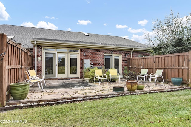 back of house with fence, a patio area, a fire pit, a lawn, and brick siding