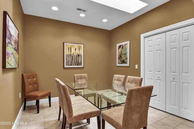 dining space with light tile patterned floors, visible vents, baseboards, and a skylight