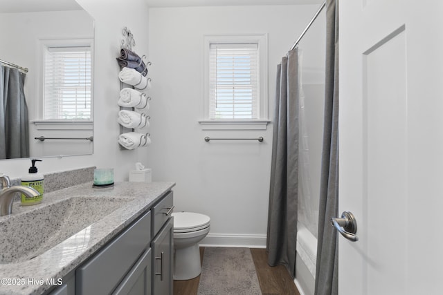 full bathroom with hardwood / wood-style floors, vanity, a healthy amount of sunlight, and toilet