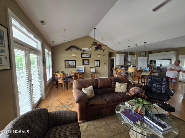 living room featuring lofted ceiling and light hardwood / wood-style floors