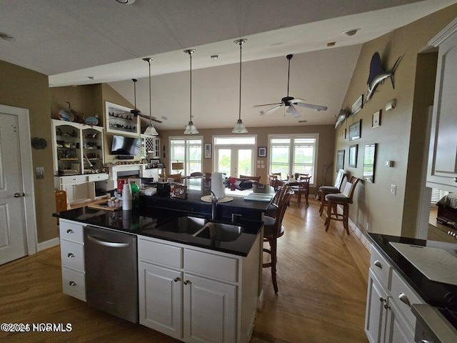 kitchen featuring dishwasher, a center island, white cabinets, and a breakfast bar