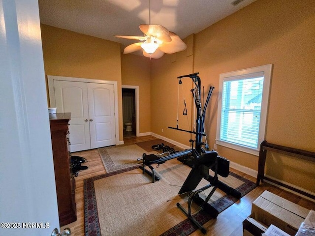 exercise room with ceiling fan and light hardwood / wood-style flooring