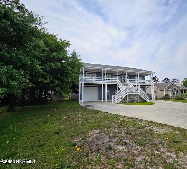 view of front of house featuring a garage, a front yard, and a porch