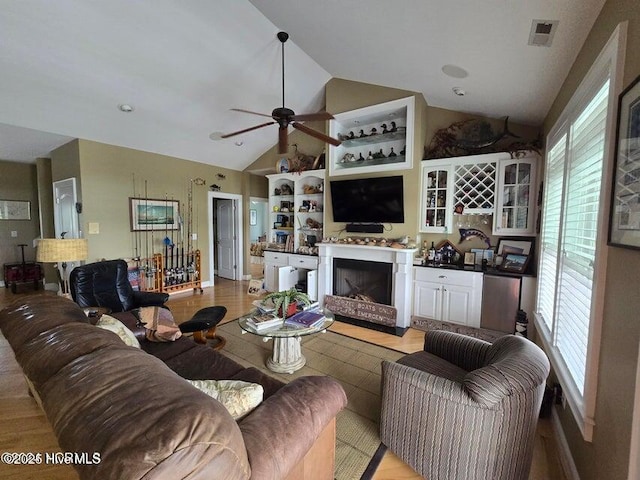 living room featuring ceiling fan and vaulted ceiling