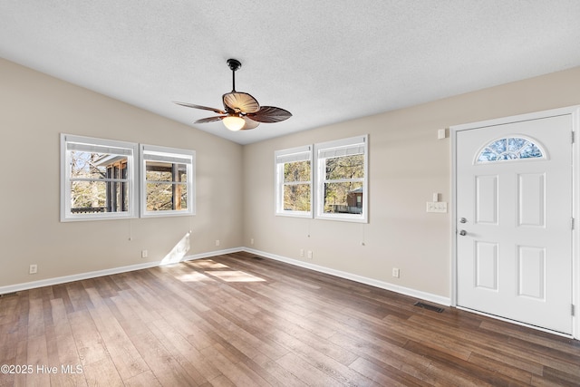 entrance foyer featuring ceiling fan, vaulted ceiling, a textured ceiling, and hardwood / wood-style floors