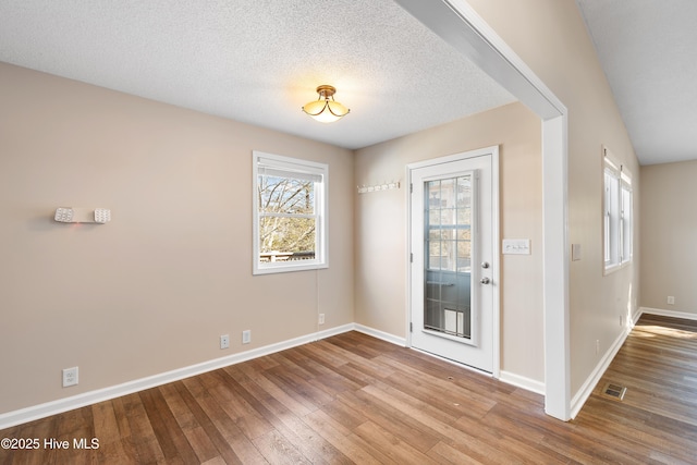 interior space featuring light wood-type flooring and a textured ceiling