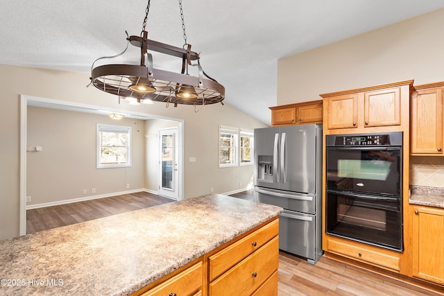 kitchen featuring backsplash, vaulted ceiling, light hardwood / wood-style floors, stainless steel refrigerator with ice dispenser, and black double oven