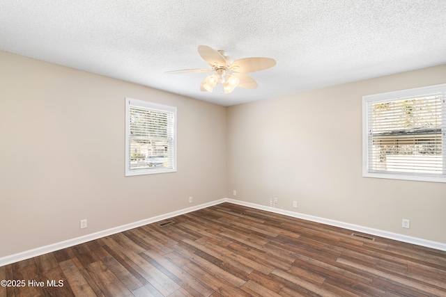 empty room with ceiling fan, a textured ceiling, and dark hardwood / wood-style flooring