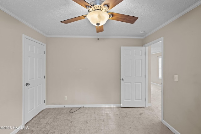 unfurnished bedroom with ceiling fan, light colored carpet, ornamental molding, and a textured ceiling