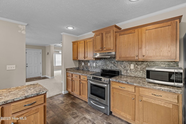 kitchen featuring dark wood-type flooring, stainless steel appliances, light stone counters, a textured ceiling, and ornamental molding