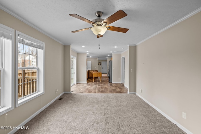 unfurnished room featuring carpet, ceiling fan, crown molding, and a textured ceiling