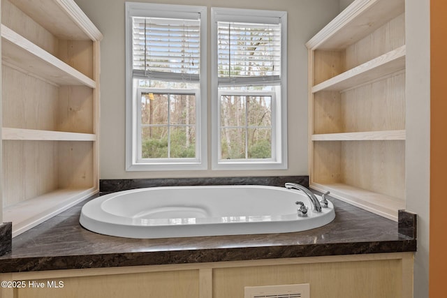 bathroom with built in features and a bathtub